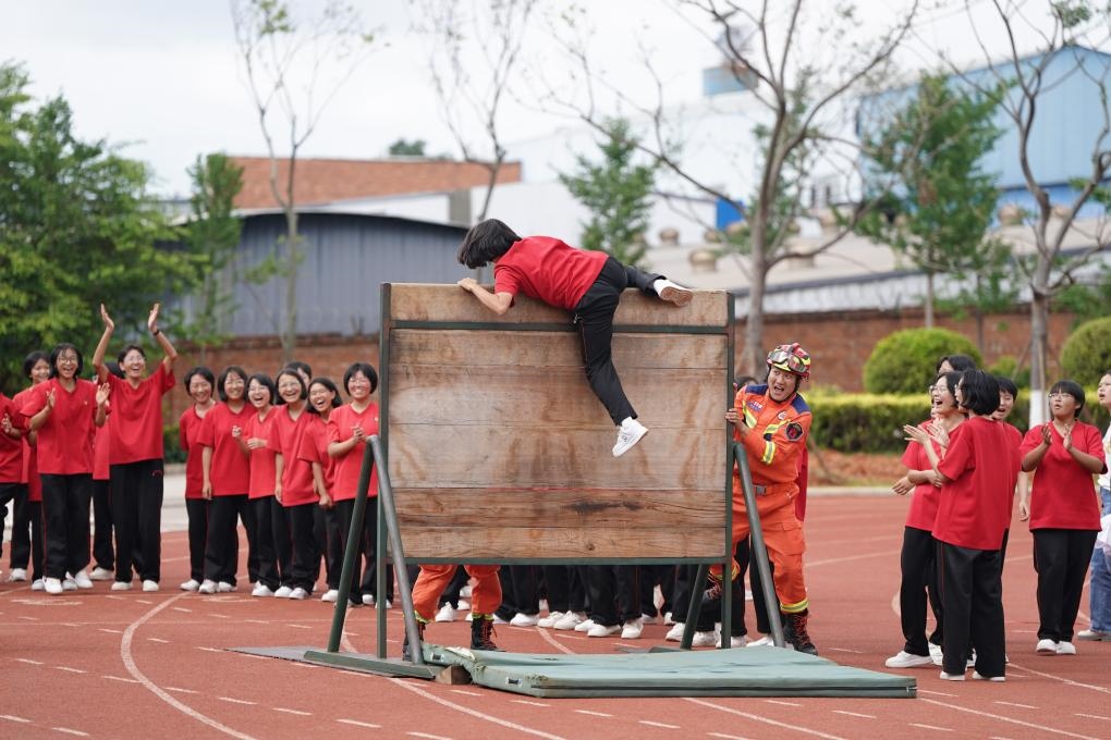 云南麗江華坪女子高級(jí)中學(xué)學(xué)生在體驗(yàn)翻越障礙板。新華社記者陳欣波 攝