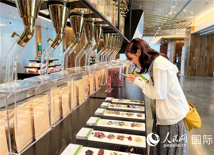 4. 代表團(tuán)團(tuán)員對(duì)新中式茶飲的食材充滿興趣。（人民網(wǎng)記者陳思 攝）