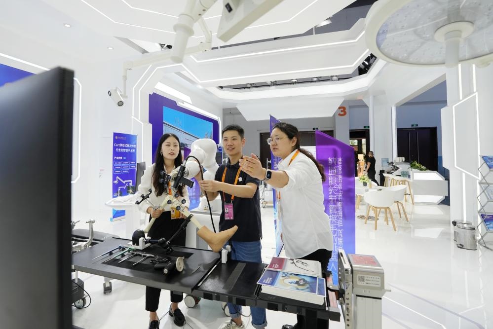9月11日，一位媒體記者（中）在2024年服貿(mào)會(huì)國(guó)家會(huì)議中心會(huì)場(chǎng)體驗(yàn)北京納通科技集團(tuán)有限公司的膝關(guān)節(jié)置換手術(shù)機(jī)器人。新華社記者鞠煥宗 攝