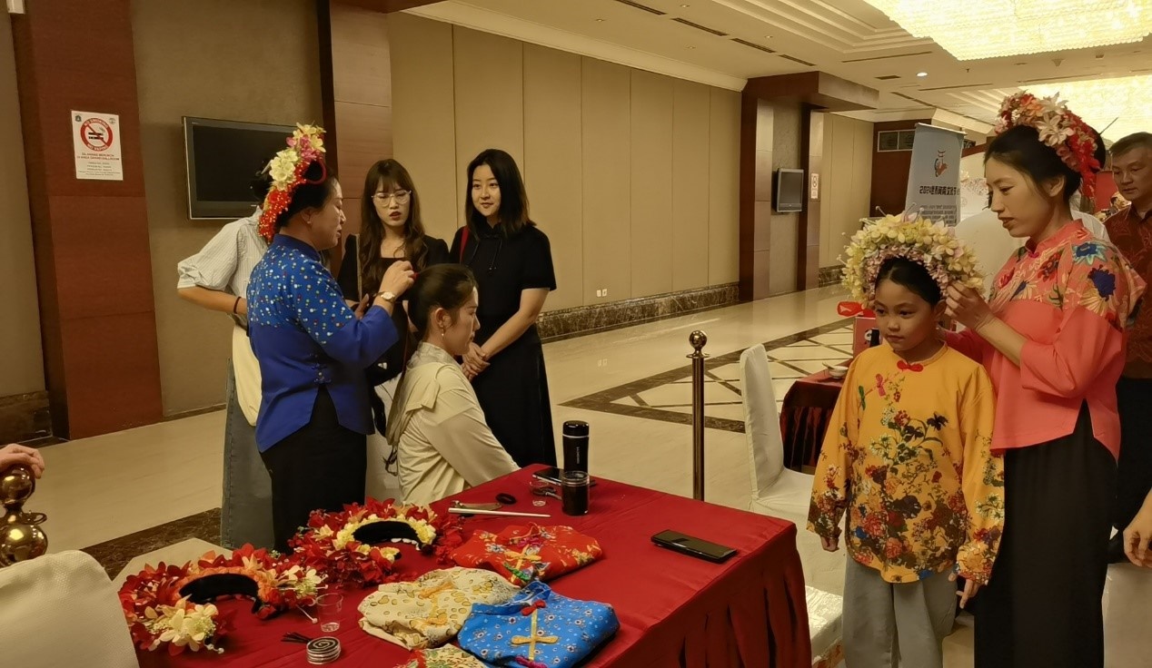 阿拉扎大學(xué)孔子學(xué)院志愿者老師向傳承人學(xué)習(xí)簪花圍。阿拉扎大學(xué)孔子學(xué)院供圖
