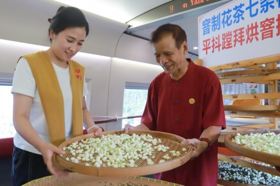 10月1日，福州市茉莉花茶窨制工藝代表性傳承人張子建與旅客在G1634次列車(chē)上制作茉莉花茶。新華社記者周義 攝