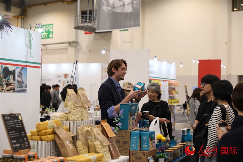 當?shù)貢r間10月5日，在第21屆釜山國際美食博覽會上，意大利展商向參觀者們介紹的意大利食品。人民網(wǎng)記者 莽九晨攝