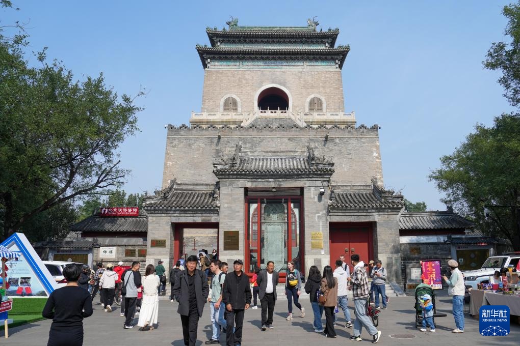 國(guó)慶假期，中外游客在北京鐘樓前參觀游覽。新華社記者 鞠煥宗攝