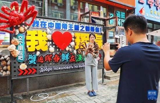 9月21日，游客在吉林省琿春市一處帝王蟹元素主題裝飾前拍照留念。新華社發(fā)