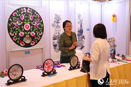 青海非遺文化傳承人向嘉賓介紹展品。人民網(wǎng)實習(xí)生姚欣可攝