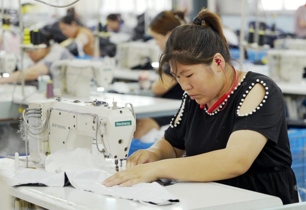 5月20日，村民在李寨村服裝加工廠內(nèi)忙碌。河南省周口市沈丘縣馮營鎮(zhèn)李寨村地處豫東平原。近年來，乘著脫貧攻堅與鄉(xiāng)村振興政策的東風，李寨村積極探索產(chǎn)業(yè)發(fā)展模式，通過“龍頭企業(yè)+村集體經(jīng)濟+農(nóng)戶”的方式，逐漸發(fā)展形成肉牛養(yǎng)殖、設(shè)施農(nóng)業(yè)、服裝加工、康養(yǎng)民宿等產(chǎn)業(yè)，以產(chǎn)業(yè)振興助力鄉(xiāng)村振興。新華社記者 李嘉南 攝