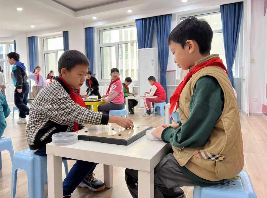 學(xué)生們?cè)谏傧汝?duì)大廳下圍棋。人民網(wǎng) 白炅攝
