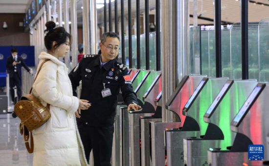 1月2日，大興機場邊檢站警察指導(dǎo)旅客使用自助出境設(shè)備。新華社記者 李欣 攝