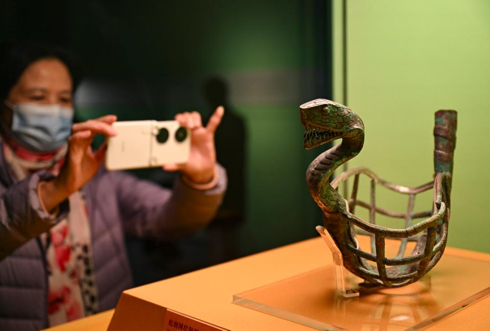 1月14日，觀眾在上海博物館蛇年迎春展拍攝展品蛇綱網(wǎng)狀銅器。新華社發(fā)（陳浩明攝）