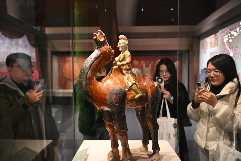 1月15日，觀眾在拍攝“長(zhǎng)安三萬里——陜西唐代文物精華展”展出的三彩胡人騎駝俑。（新華社記者 孫凡越 攝）