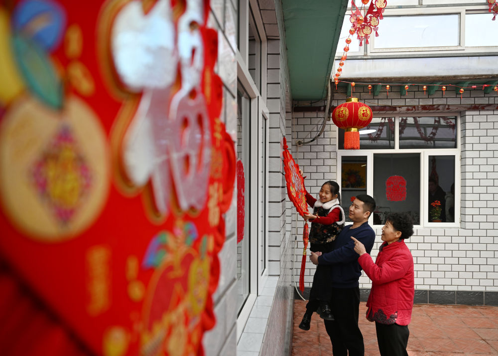 天津市西青區(qū)辛口鎮(zhèn)第六埠村村民在院子里掛“福”字（2024年2月1日攝）。新華社記者 趙子碩 攝