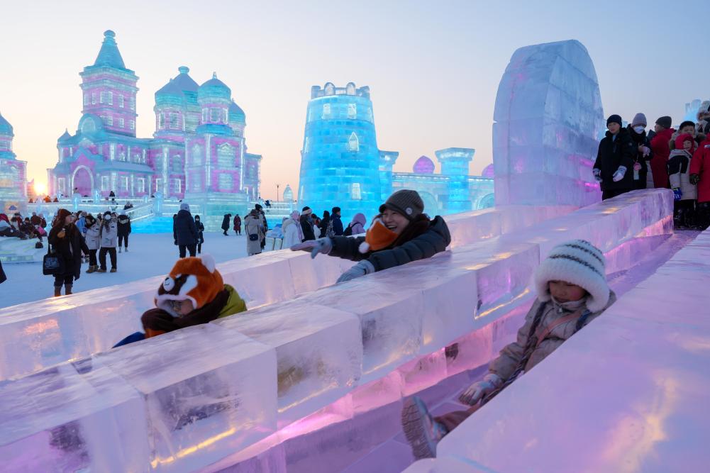 游客在哈爾濱冰雪大世界園區(qū)內(nèi)體驗(yàn)冰滑梯。新華社發(fā)