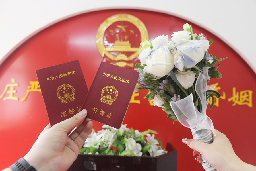 2024年8月10日，一對新人在河北石家莊新樂市民政局婚姻登記處領(lǐng)取結(jié)婚證后拍照留念。新華社發(fā)（賈敏杰攝）