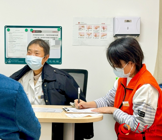 秦苑（中）接診患者。人民網(wǎng)記者 金慧慧攝