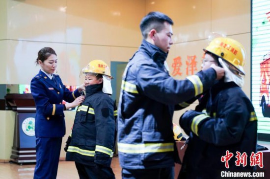 圖為學(xué)生們現(xiàn)場穿戴消防頭盔和戰(zhàn)斗服。中新社記者 趙宇航 攝
