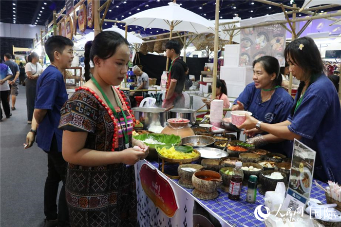 游客在攤位前購買特色美食。朱瀟逸攝