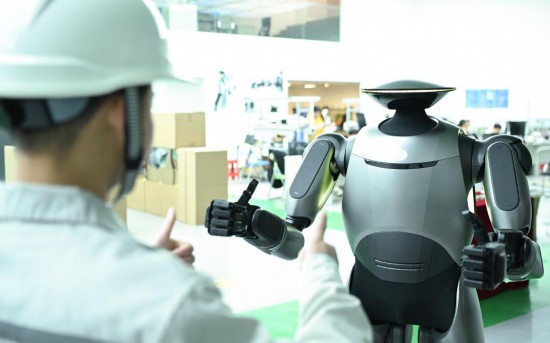 在廣汽研究院，人形機器人團隊的周仁義在演示GoMate機器人互動功能（新華社記者 鄧華 攝）