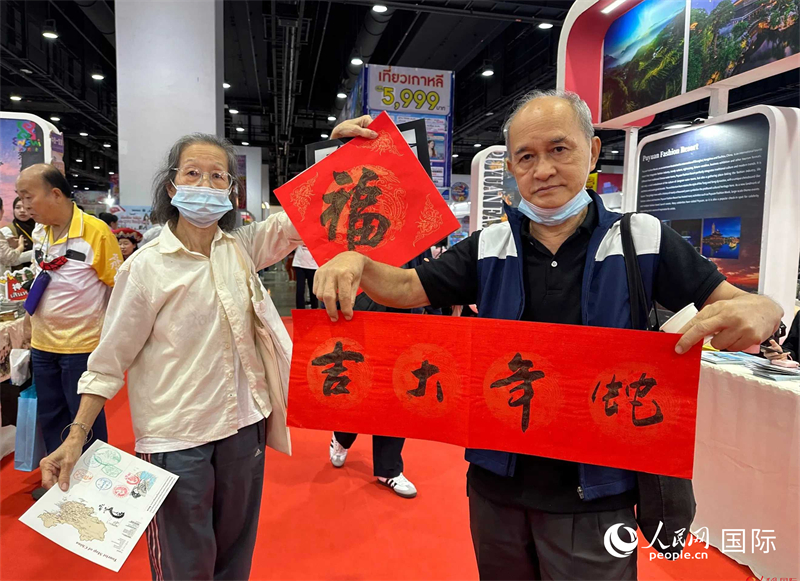 2025蛇年春節(jié)，泰國(guó)市民展示他們領(lǐng)到的華人手寫春聯(lián)。人民網(wǎng)記者 簡(jiǎn)承淵攝