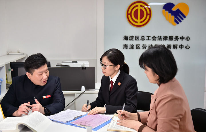 2025年3月6日，在北京市海淀區(qū)總工會勞動爭議調(diào)解中心，海淀區(qū)人民法院法官王琰（中）與該中心工作人員就糾紛化解情況進行溝通。新華社記者 趙婷婷 攝