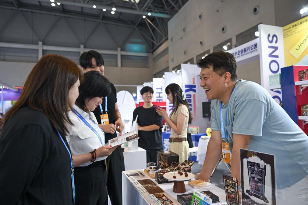 5月22日，韓國(guó)展商（右一）在西洽會(huì)現(xiàn)場(chǎng)向參觀者介紹產(chǎn)品。新華社記者 陳誠(chéng) 攝