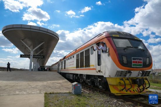 5月31日，在蒙內(nèi)鐵路內(nèi)羅畢站，機車駕駛員蔣立平（右）和博爾在即將開往蒙巴薩的E2次列車上揮手致意。新華社記者 楊光 攝